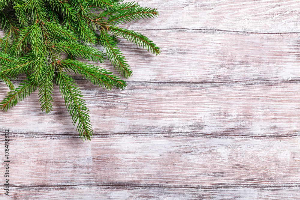 green fir branches on a light wooden background, horizontal green fir branches on a light wooden background, horizontal