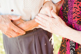 Elderly couple holding hands in summer park
