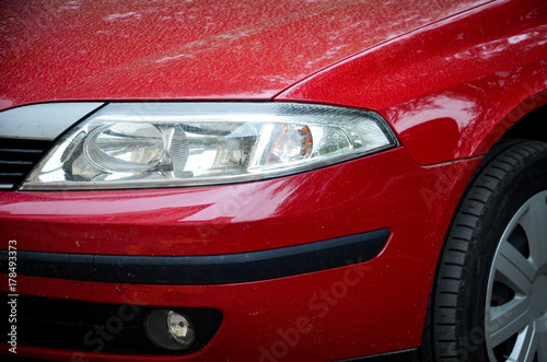 Headlight and part of tire of the red car © emiphoto111
