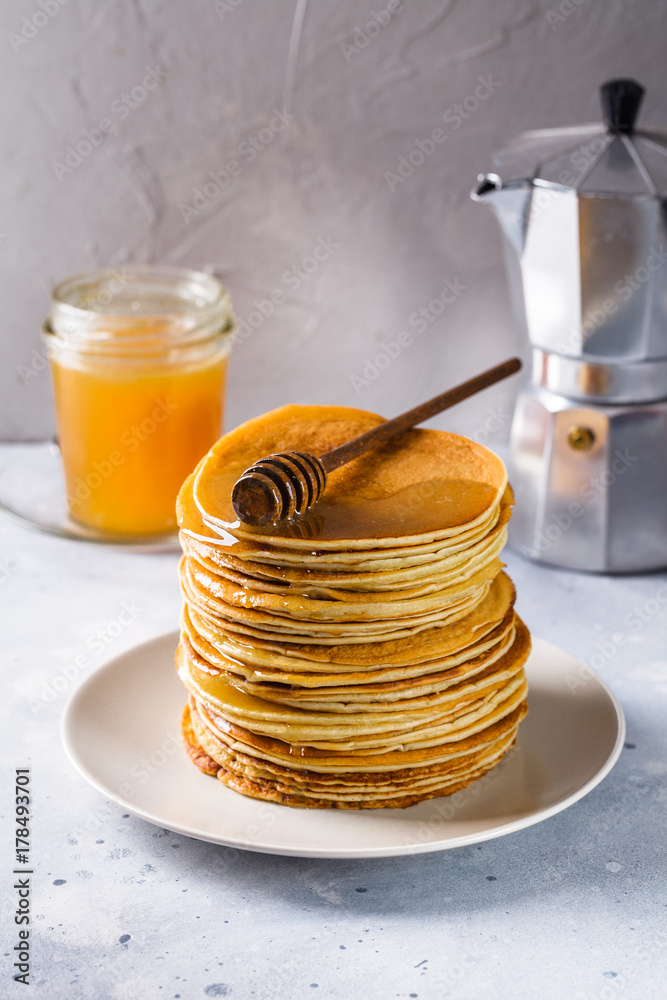 Pancakes with honey on a gray background