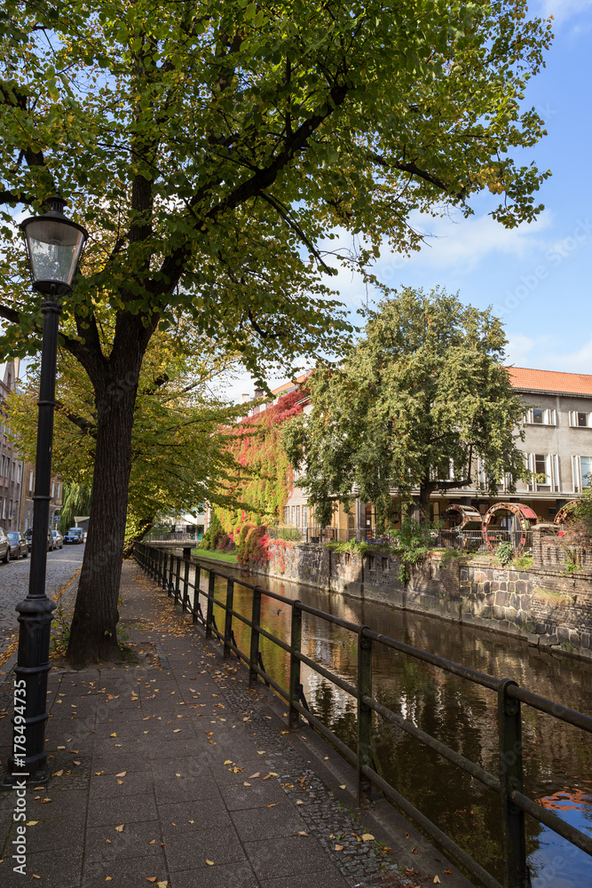 View of an idyllic sidewalk and canal on a sunny day in Gdansk, Poland, at autumn.