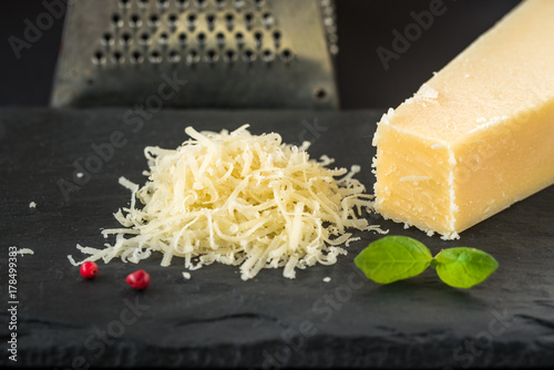 Grated parmesan cheese and metal grater.