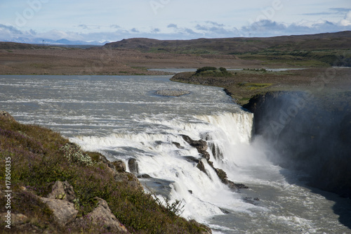 Typical Icelandic landscape of Gullfos Falls, a wild nature of rocks and shrubs.