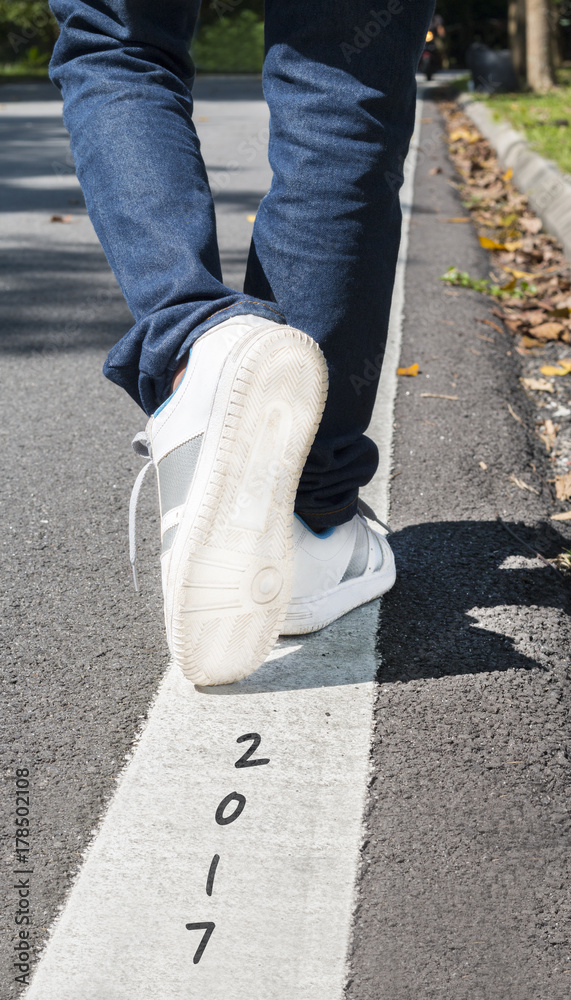 Low section view of a man walking and leaving behind year 2017. New year 2018. Low section view of a man walking and leaving behind year 2017. New year 2018.