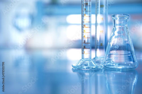 glass flask with cylinder in blue science laboratory background