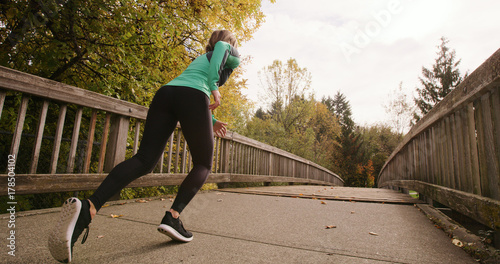 Runner Woman Running In Park Exercising Outdoors on Bridge © maxwellmonty