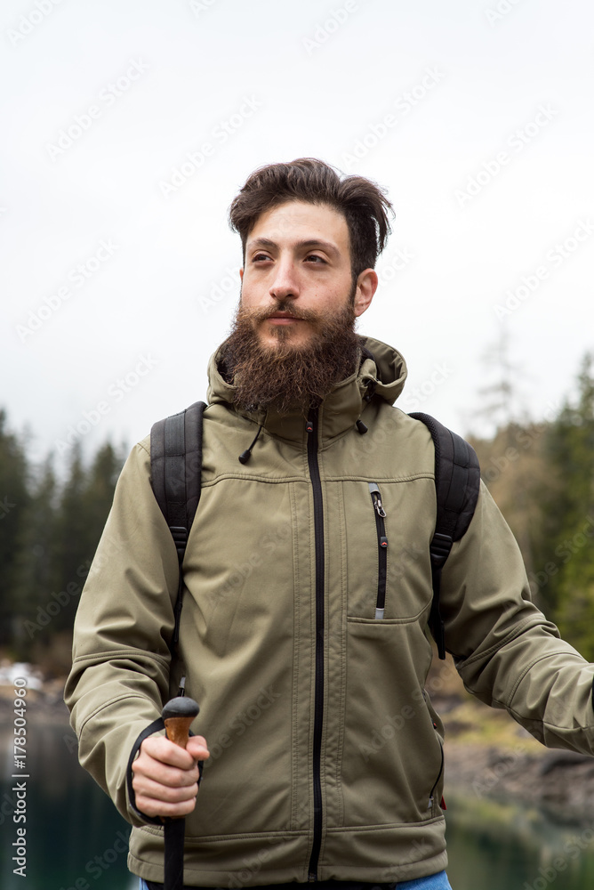 Hipster Adventurer hikes along Lake Obernberg in the mountains of Austria