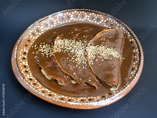 Delicious mexican enchiladas, chicken or turkey tacos with mole sauce and sesame seeds for traditional festivities