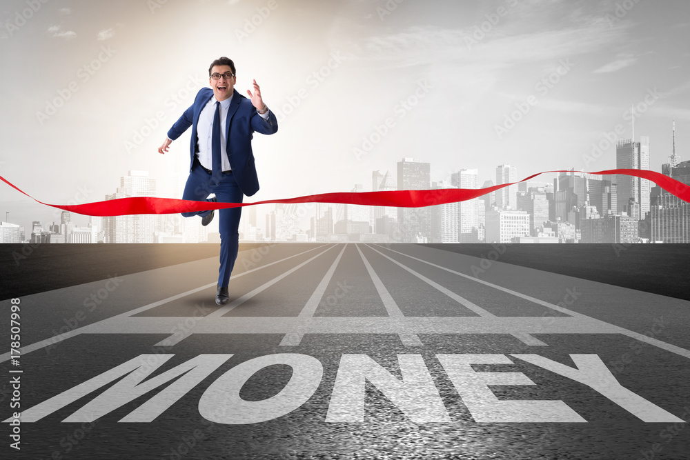 Businessman running towards money on track Businessman running towards money on track