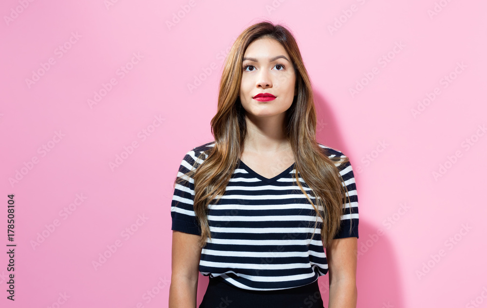 Portrait of a young woman standing against a solid background Portrait of a young woman standing against a solid background