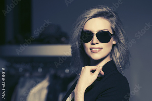 Young fashion blond woman in sunglasses in the mall interior
