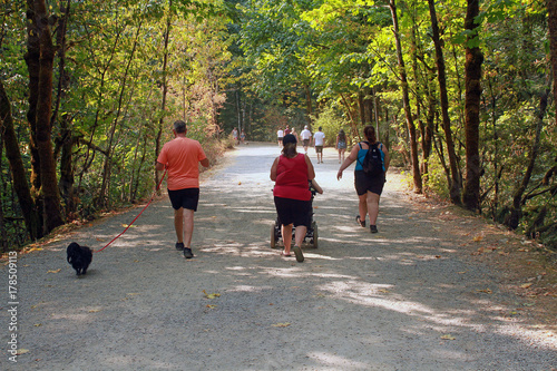 Four people hiking with a black dog.  One of the people is being