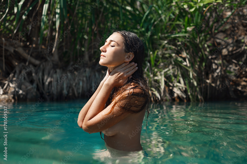 attractive young naked woman in water outdoors attractive young naked woman in water outdoors