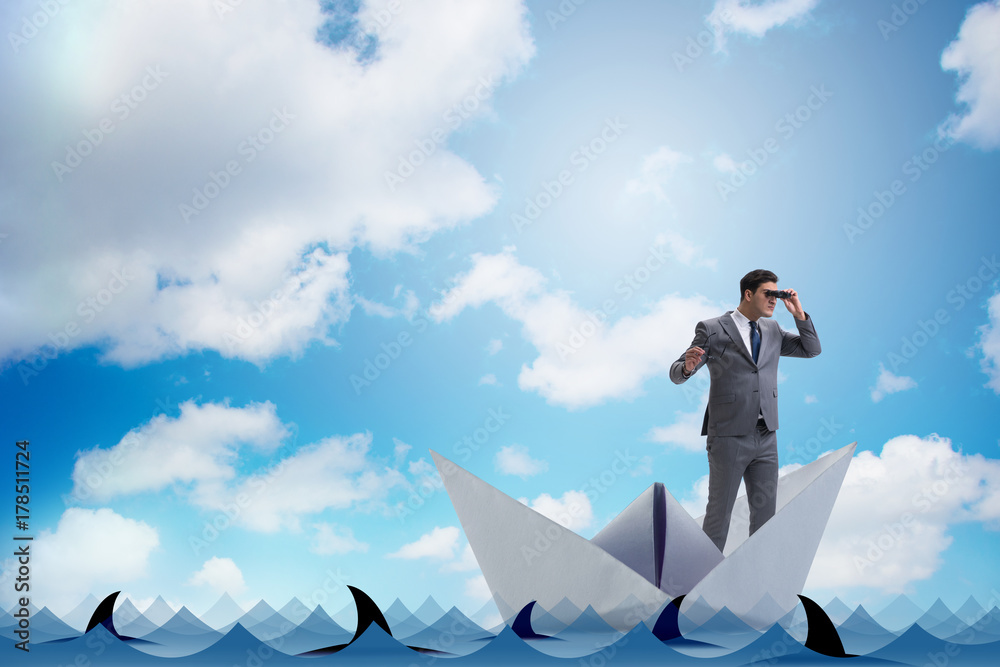 Obraz premium Businessman looking into future with binoculars in paper ship bo