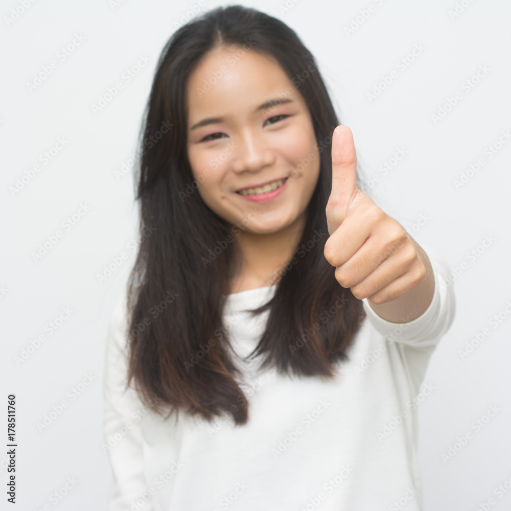 Happy young woman giving thumbs up isolated on white background Happy young woman giving thumbs up isolated on white background