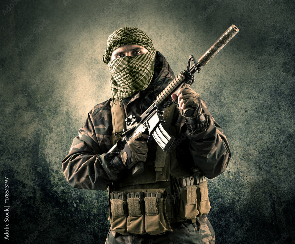 Portrait of a heavily armed masked soldier with grungy background Portrait of a heavily armed masked soldier with grungy background