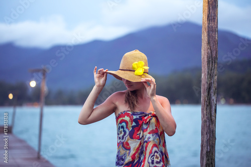 girl in hat on the pier in the evening