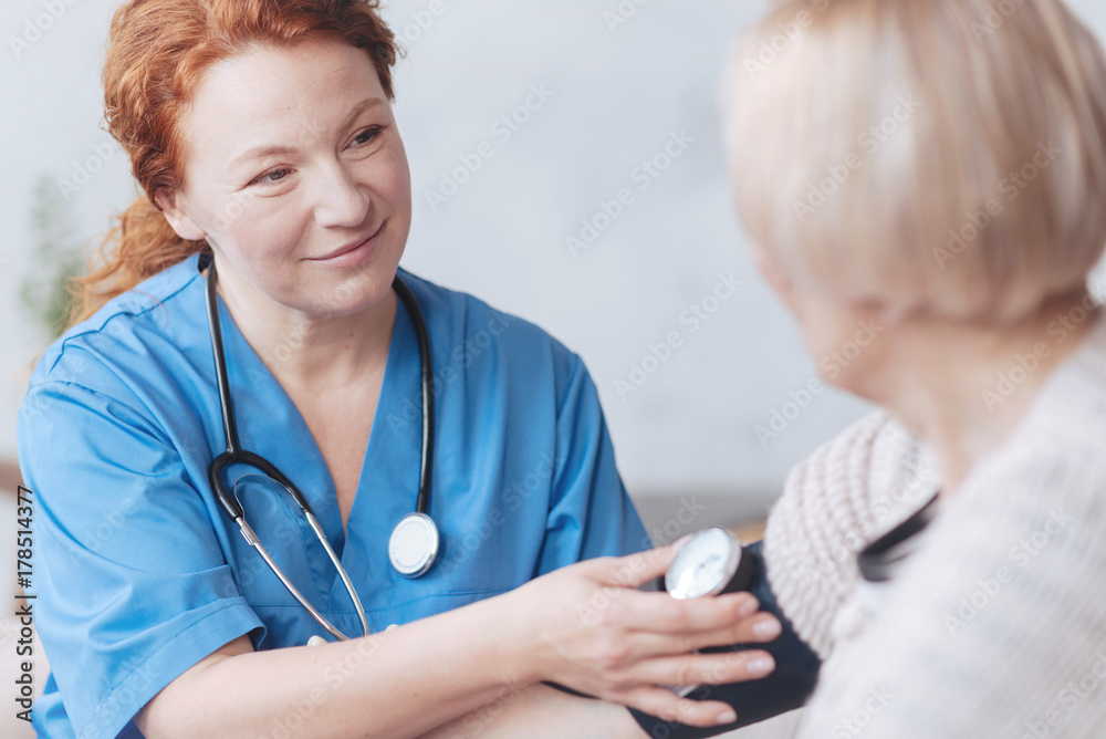 Thoughtful medical worker measuring blood pressure Thoughtful medical worker measuring blood pressure