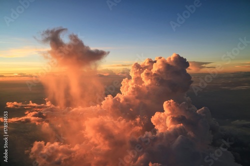 Beautiful view from airplane's window with blue sky, big red cloud in the evening . Soft focus with low key.