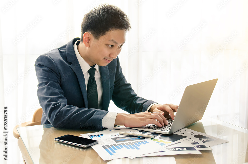 Happy young businessman daydreaming smile at white workplace with his laptop. Success concept Happy young businessman daydreaming smile at white workplace with his laptop. Success concept