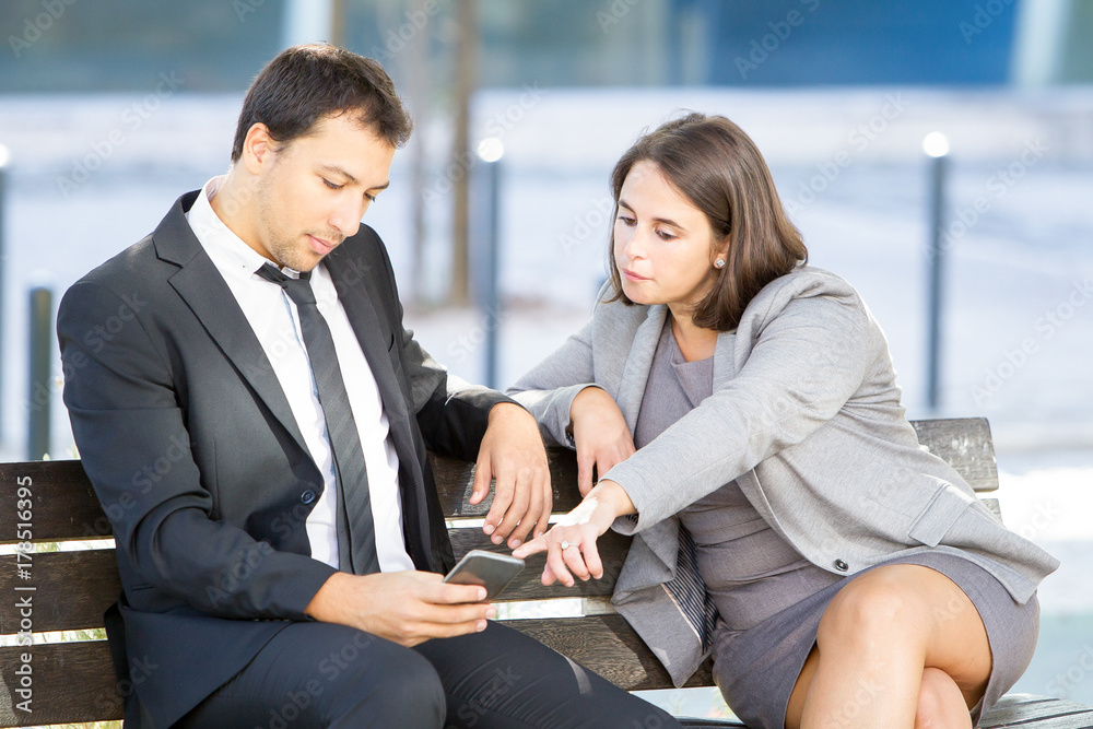 Colleagues Browsing on Smartphone Outdoors Colleagues Browsing on Smartphone Outdoors