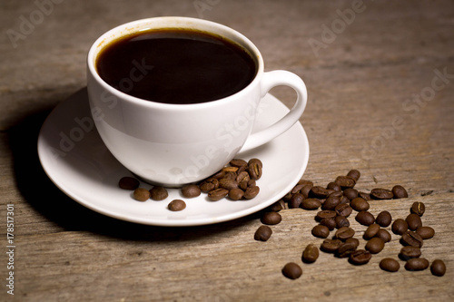 Coffee in cup with coffee beans with wooden background in studio