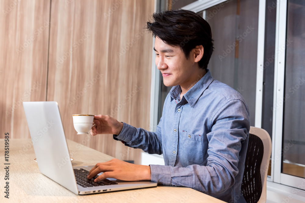 Fototapeta premium Businessman hand holding coffee cup and working in the Office with labtop Concept.
