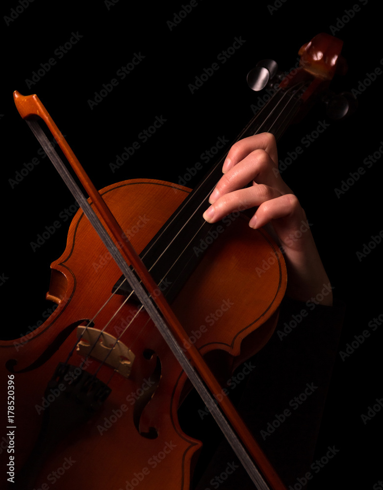 Bow and female fingers on violin strings isolated on black background Bow and female fingers on violin strings isolated on black background