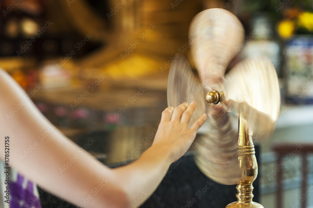 Obraz premium Worshipper at Che Kung Temple, Tai Wai, spinning a brass wheel of fortune