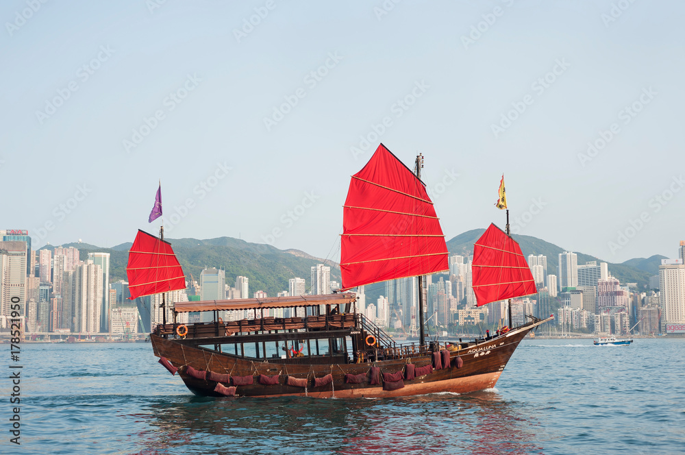 Obraz premium A tourist tour junk crosses Victoria Harbour, Hong Kong