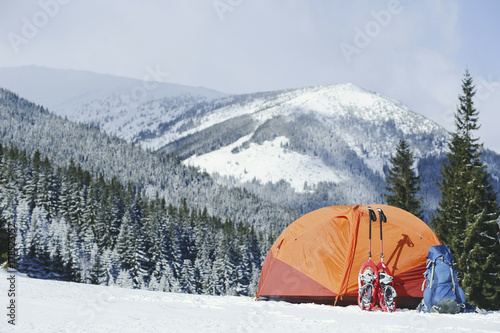 Winter Trekking in the mountains. The tent is on top of the mountain.