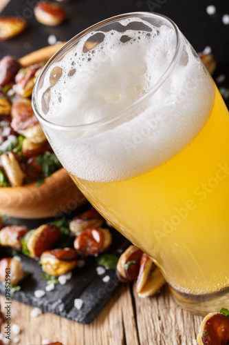 glass of light beer with a snack of fried beans macro on the table. vertical