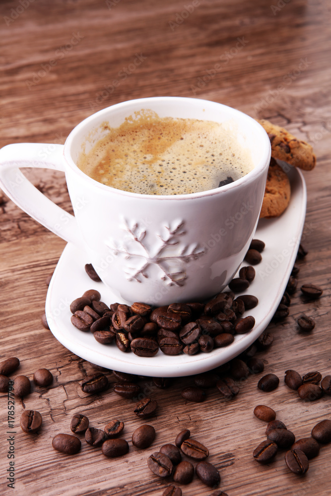 Coffee cup with chocolate cookies and coffee beans on wooden background Coffee cup with chocolate cookies and coffee beans on wooden background