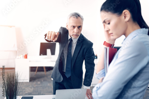 Fotografie Frustrated male boss fingering at door while firing office worker