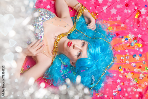 beautiful happy bright young girl with blue hair lying alone in the long evening dress with rhinestones top view