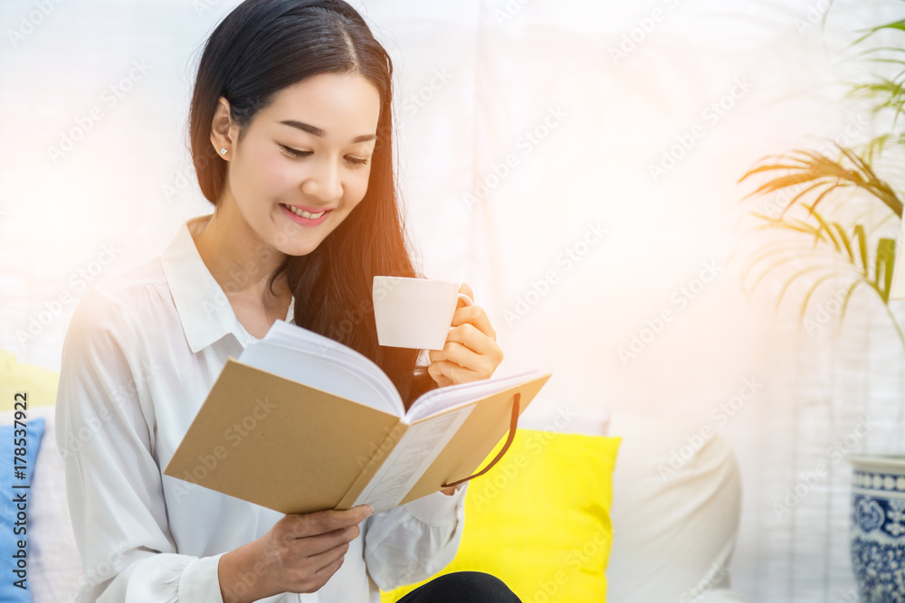 beautiful asian woman sit relax reading book with tea or coffee white room interior beautiful asian woman sit relax reading book with tea or coffee white room interior