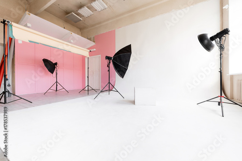 large studio space white cyclorama and natural light from large windows. lighting equipment and flash