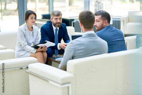 Group of business people discussing partnership contract during negotiation meeting in modern office