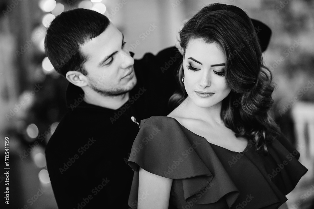 Fashion portrait of a hot couple. man touching hair of his elega Fashion portrait of a hot couple. man touching hair of his elega