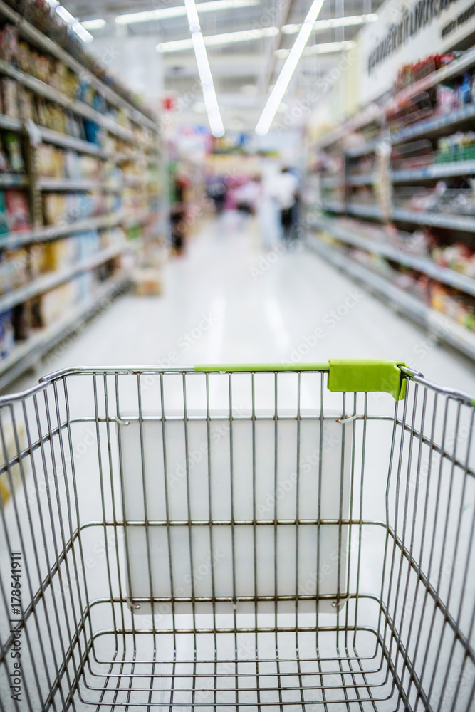 Supermarket aisle black friday sale with empty green shopping cart Supermarket aisle black friday sale with empty green shopping cart