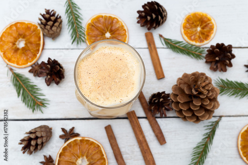 Homemade eggnog with cinnamon on wooden table. Christmas drinks