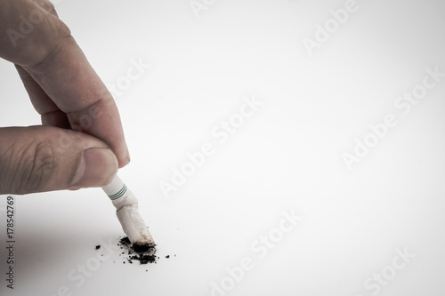 A hand push the cigarette stub on white background, Symbolic stop smoking concept, Free space for text