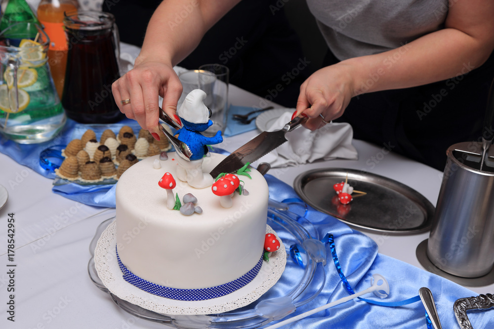 Tort urodzinowy dla małego chłopca i ciasta na stole, krojenie tortu. Tort urodzinowy dla małego chłopca i ciasta na stole, krojenie tortu.