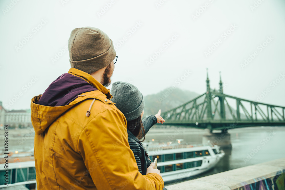 man pointing while standing near river in foggy morning