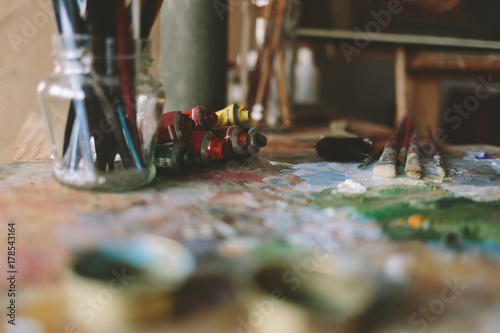 Artistic paintbrushes, tubes of paint and palette knife.