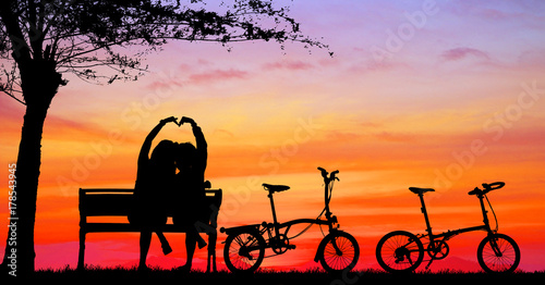 silhouette vintage bike and love couple in the holiday on sunrise time