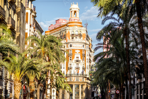 Street view with beautiful luxurious building and palm trees in Valencia city during the sunny day in Spain photo