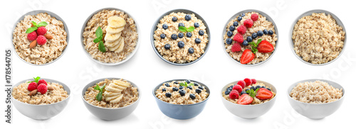 Bowls of oatmeal with berries and fruits on white background photo