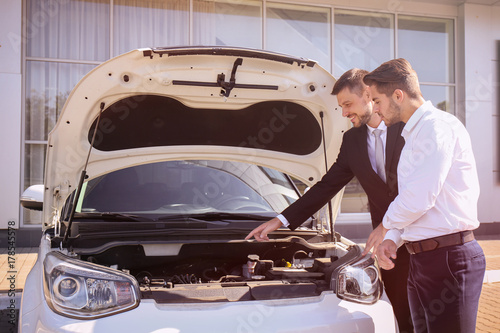 Salesman showing new car to...
