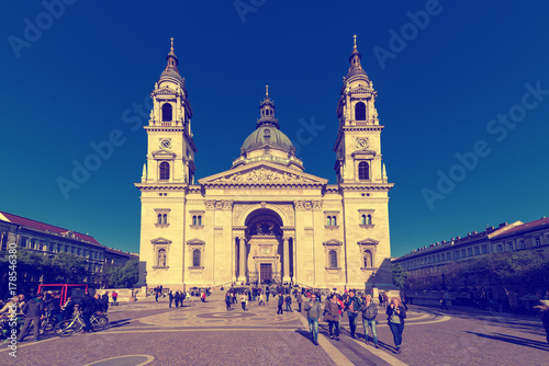 Facade of St. Stephen's Basilica aka st. Istvan in Budapest, Hungary with tourists and blue sky. Travel outdoor hungarian background